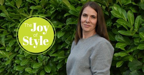 A woman standing in front of a green wall.