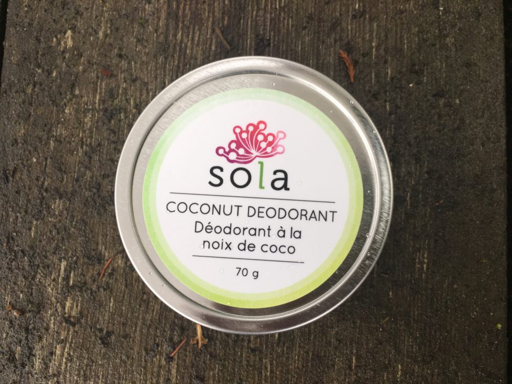 A jar of deodorant sitting on top of a wooden table.