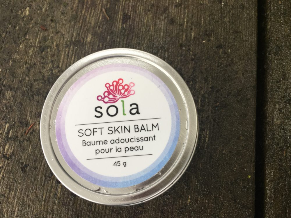 A container of sola skin balm on top of a table.