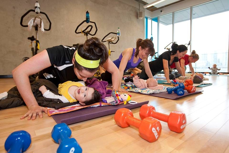 A group of people doing different exercises on the floor.